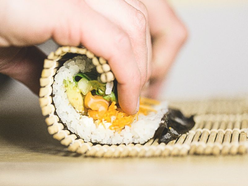 Someone rolling sushi