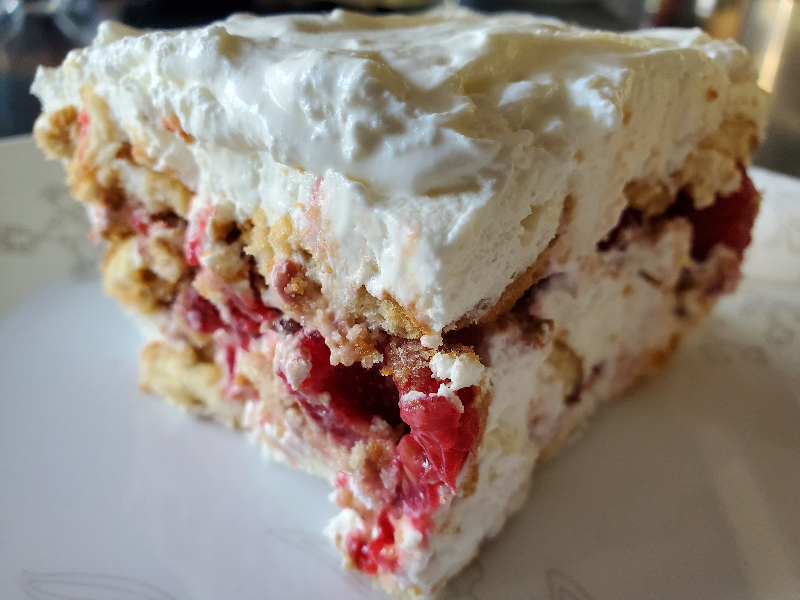 A photo of a slice of raspberry and whipped ice box cake.
